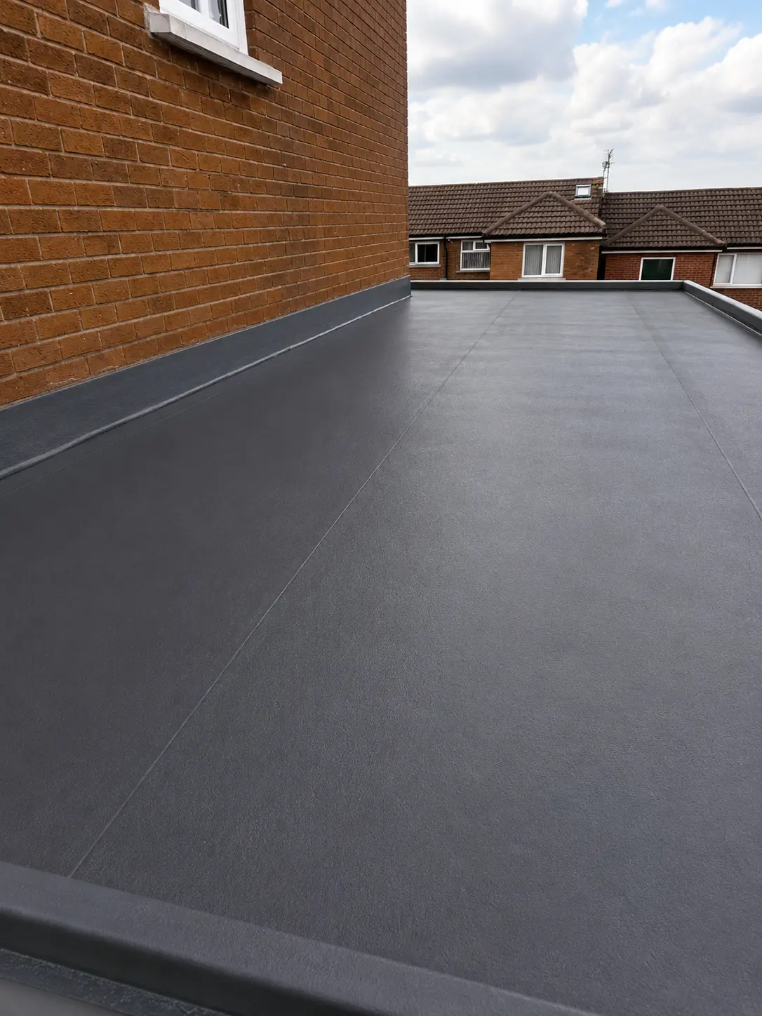 Grey GRP fibreglass flat roof on a brick house